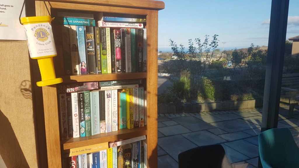 Wooden book shelf in Polmanter reception full of books