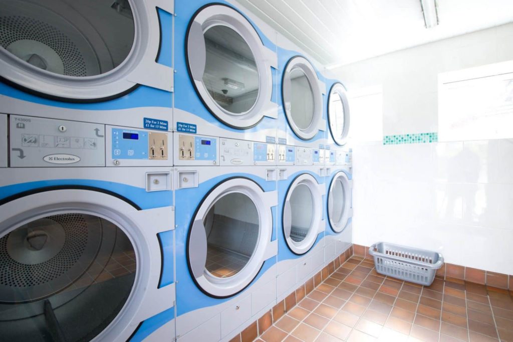 Side view of 6 coin operated tumble dryers in Polmanters laundry room