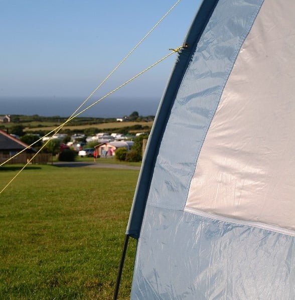 Blue tent pitches in the Movah field with views of the sea