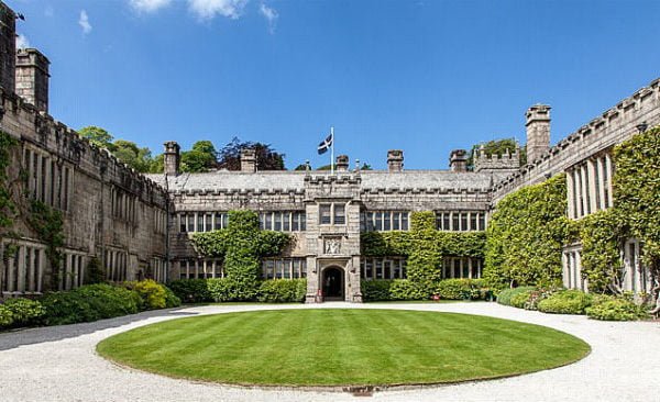 Lanhydrock house and lawn with a bright blue sky