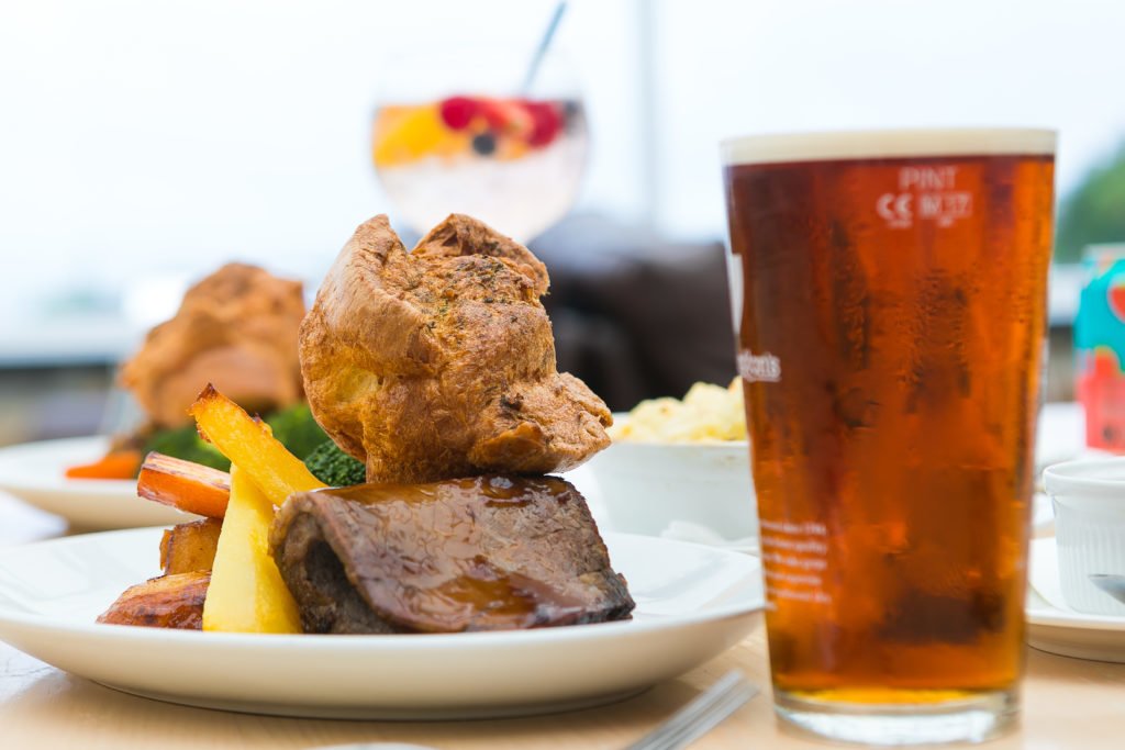 Roast beef dinner with Yorkshire pudding and a cold pint of beer